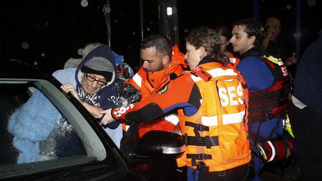 Ambulance officers and SES Crew help residents of Freeman Ave, Canley Vale who had to evacuate their homes as flood waters began to rise. Picture: John Appleyard