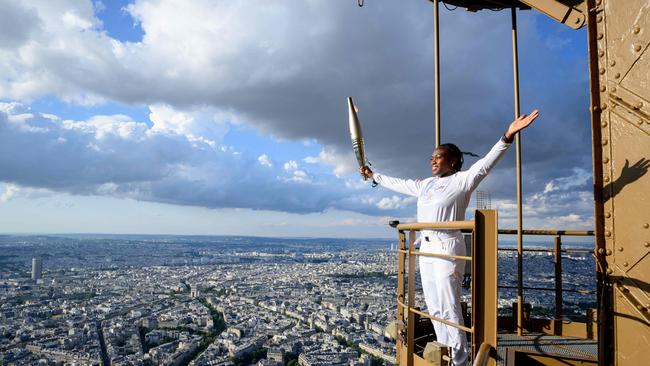 French judoka Clarisse Agbegnenou holding the Olympic Torch on the Eiffel Tower as part of the Olympic torch relay in Paris. Picture: AFP Photo/Paris 2024/Lionel Hahn