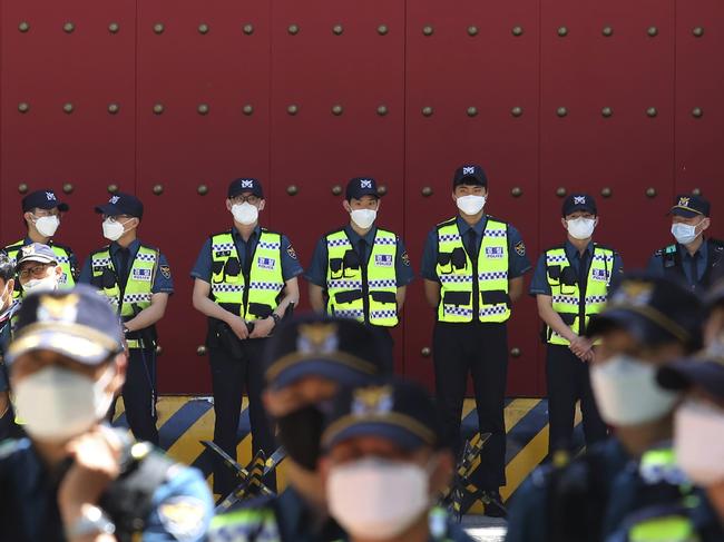 Police officers wearing stand guard in front of the Chinese embassy in Seoul, South Korea. Picture: AP