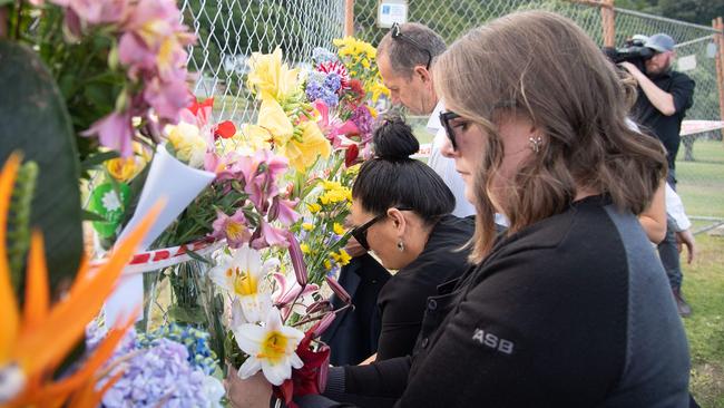 Bouquets of flowers are placed on the waterfront near White Island Tours base. Picture: AFP