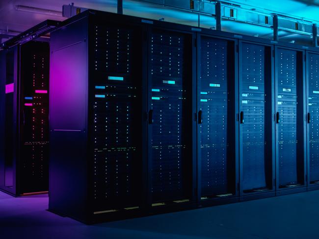 In Data Center: IT Technician Running Maintenance Programme on Laptop, Controls Operational Server Rack Optimal Functioning. Modern High-Tech Telecommunications Operational Data Center in Neon Lights.