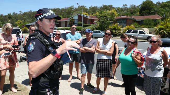 An officer speaks to concerned parents outside Helensvale Primary School after it went into lockdown. Photograph: Jason O'Brien