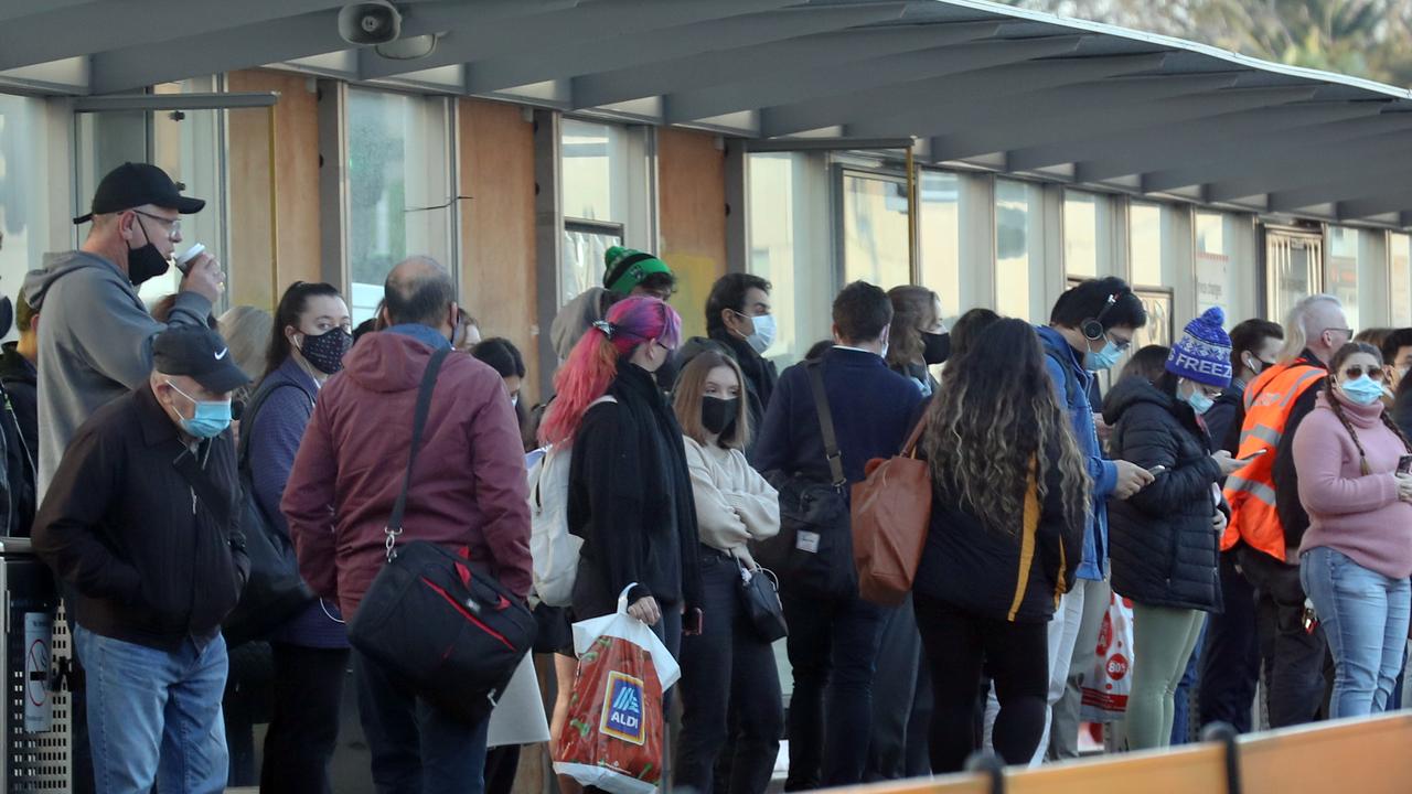 Masked up commuters wait at a tram stop outside Flinders Street Station on Monday. Picture: David Crosling / NCA NewsWire