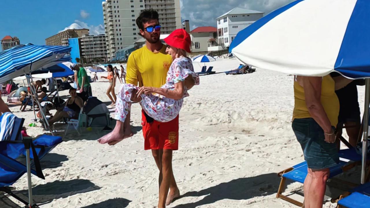 The group would carry the elderly woman to the beach every day for one week so she could enjoy her holiday. Picture: Orange Beach Surf Rescue