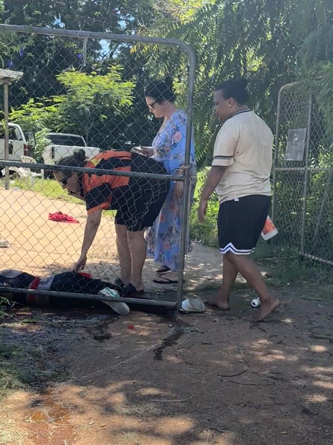 Witnesses help the woman who is almost motionless on the ground. Picture: supplied