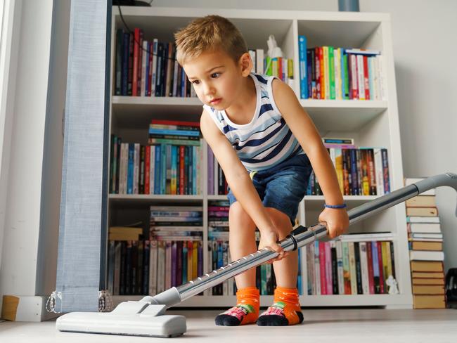 Little kid using vacuum cleaner at home - Small boy cleaning floor in apartment - Child doing housework having fun - side view full length in summer day - childhood development real people concept