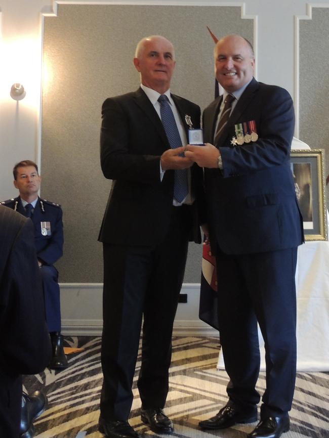 Retired Detective Sgt Kevin Fitzgerald receives his NSW Police Medal 35 year clasp from Baulkham Hills state Liberal MP and Minister David Elliott.