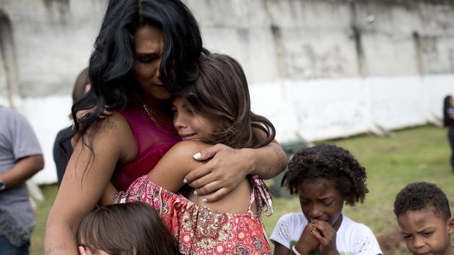 Female inmate Rossana Goncalves with four of her five children cry as they reunite on the sidelines of competing in her jail's annual beauty contest. Picture: AP Photo/Silvia Izquierdo.