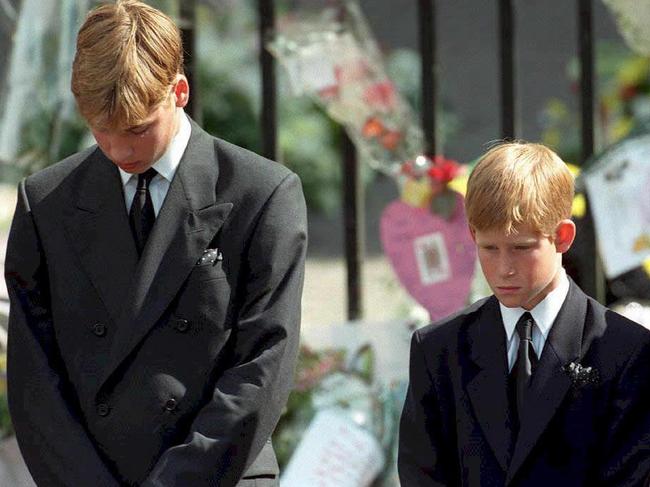 (FILES) This file photo taken on September 6, 1997 shows Britain's Prince William (L) and Prince Harry, the sons of Diana, Princess of Wales, bowing their heads as their mother's coffin is taken out of Westminster Abbey, following her funeral service. Two decades on from the death of princess Diana, her sons Princes William and Harry are working to keep her legacy alive with unusually emotional tributes after years of official silence. William was 15 and Harry 12 when Diana died in a car crash in Paris on August 31, 1997. / AFP PHOTO / ADAM BUTLER