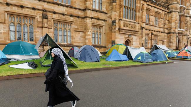 A protester walks past the tent encampment. Picture: NCA NewsWire / David Swift