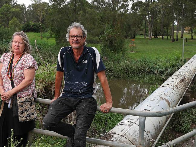 Jo and Allan Clark-Jones (with dog Henry) talking about a lack of flood mitigation in Stable Swamp Creek, Rocklea. Pics Adam Head