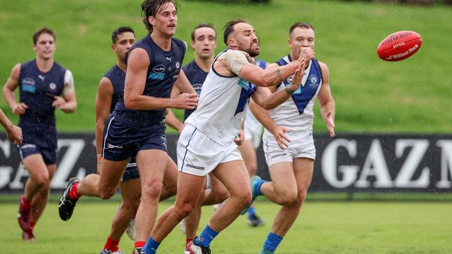 Dane Crognale handballs for University Blues. Picture: George Sal