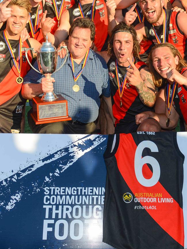 Terry Birkin holds the cup next to TTG captain Alex McKay with Jon Birkin’s number six guernsey in the foreground.