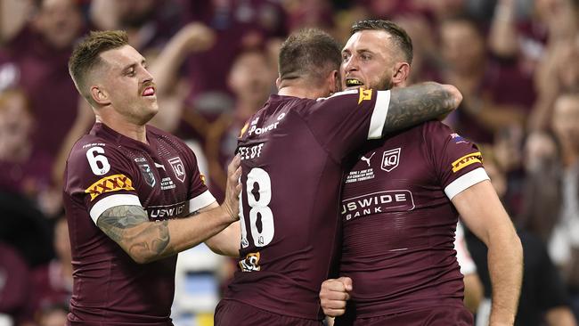 Cameron Munster and Kyle Feldt celebrate with Kurt Capewell after he scored the Maroons only try on Wednesday night. Picture: Ian Hitchcock/Getty Images