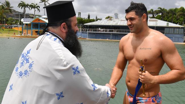 The celebration of the Epiphany is one of the most sacred in the calendar of the Greek Orthodox faith. It is the throwing of the Cross Ã&#144; and blessing of the waters. Held in Townsville at the rock pool. Father Sotirios Papafilopoulos with Yani Collocott who found the cross in the water after it had been thrown. Picture: Evan Morgan