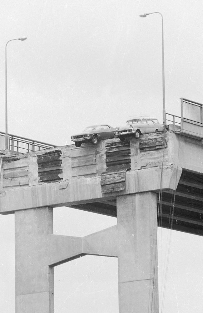 Two cars dangle over the edge the morning after the Tasman Bridge collapse in 1975. Picture: News Limited