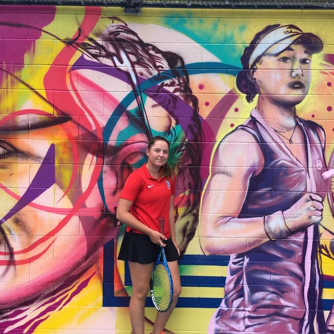 Kelvin Grove State College tennis players Sydney Stone in front of the Ashleigh Barty mural at the Queensland Tennis Centre.