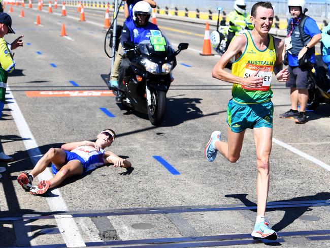Michael Shelley of Australia (right) passes Callum Hawkins of Scotland as he collapses after being in the lead of the Men's Marathon Final on day eleven of competition at the XXI Commonwealth Games on the Gold Coast, Australia, Sunday, April 15, 2018. (AAP Image/Tracey Nearmy) NO ARCHIVING, EDITORIAL USE ONLY