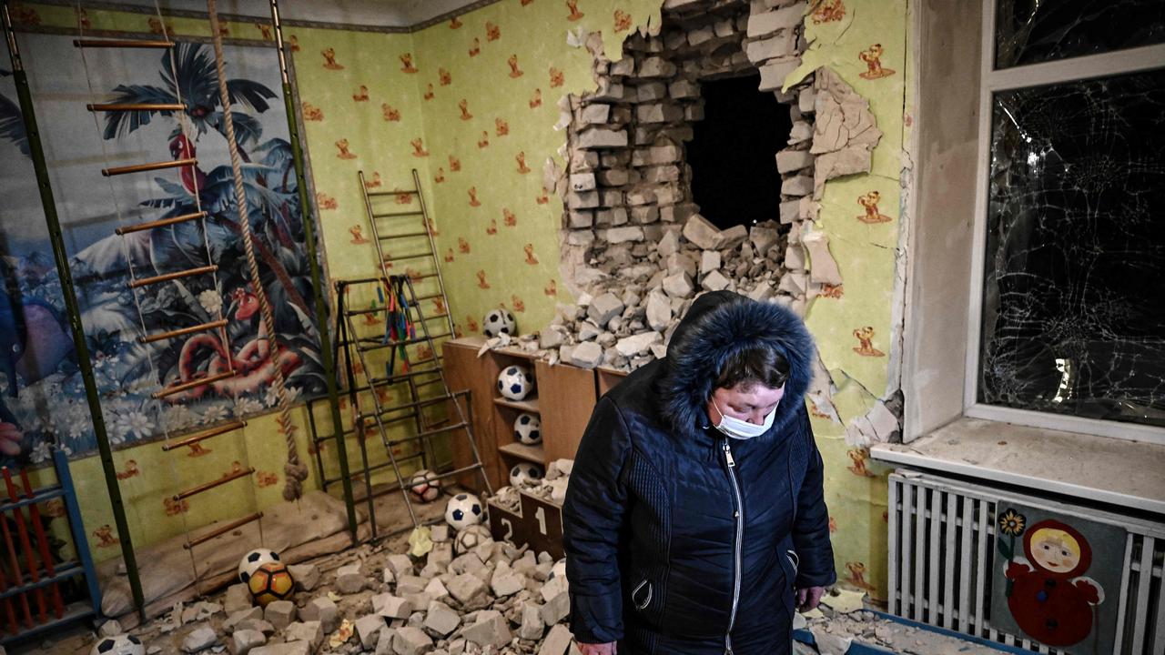 A woman stands inside among debris after the reported shelling of a kindergarten in the settlement of Stanytsia Luhanska, Ukraine. Picture: Aris Messinis/AFP