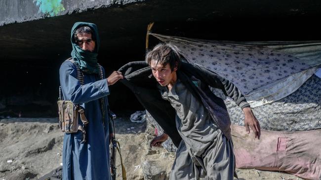 A Taliban member detaining a drug addict under a bridge where hundreds of addicted people gather in Kabul. Picture: AFP