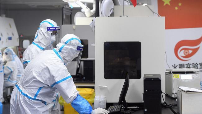 Laboratory technicians working on samples to be tested for the coronavirus at the Fire Eye laboratory in Wuhan, in China's central Hubei province. Picture: AFP