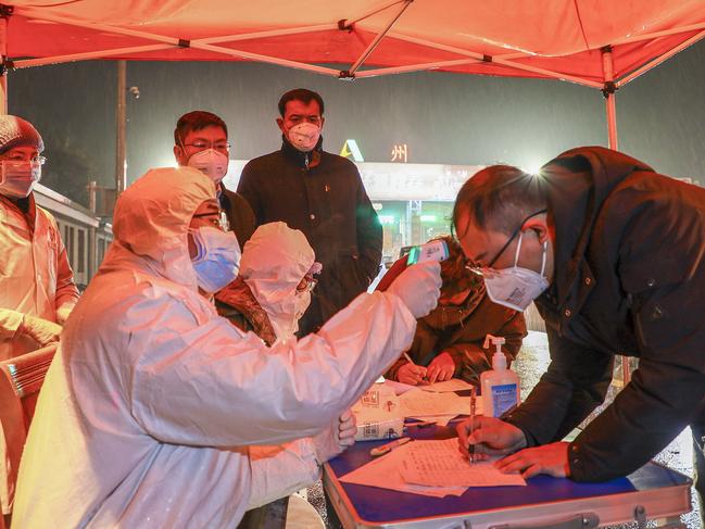 A medical staff member checking the temperature of a driver at a highway check point in Tengzhou in China’s eastern Shandong province. Picture: STR/AFP