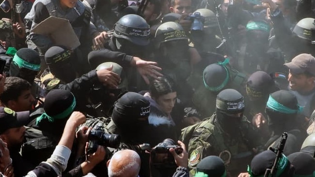 Hamas members Thursday escorted Arbel Yehoud, an Israeli civilian, through the crowd in Gaza to Red Cross workers. Picture: Naaman Omar/Zuma Press