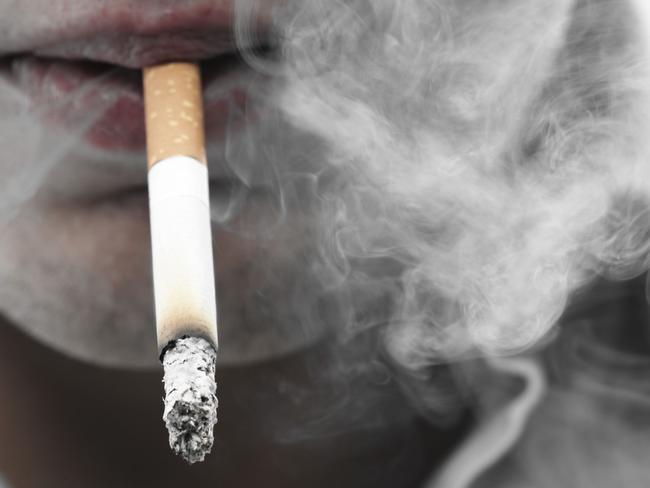 Close-up of mouth with cigarette between lips, smoking.