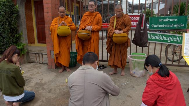 People pray to Buddhist monks near the hospital where the rescued boys are being treated. Picture: AFP.