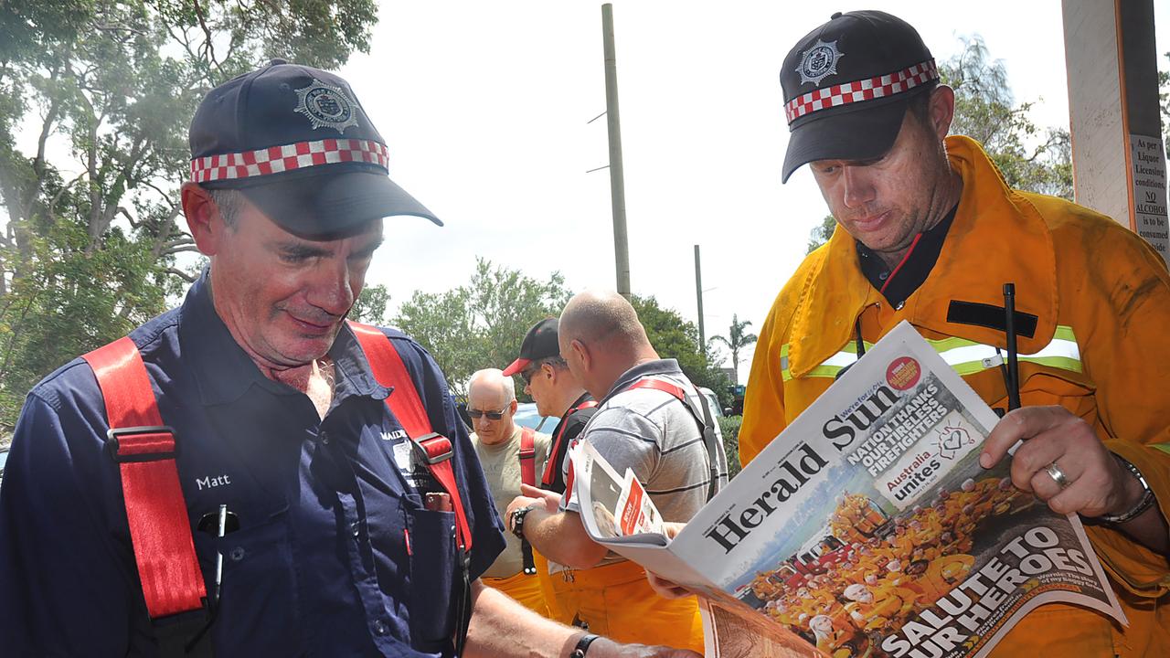 CFA firefighters reading the Herald Sun during the bushfire crisis. Picture: Jacquie Wilson