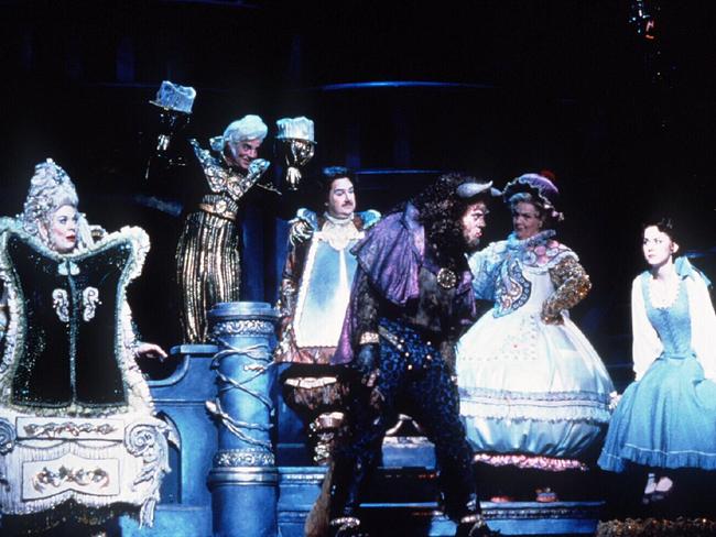 Bert Newton as Cogsworth alongside other Beauty and the Beast characters Madame, Lumiere, the Beast, Mrs Potts and Belle on stage at the Princess Theatre.