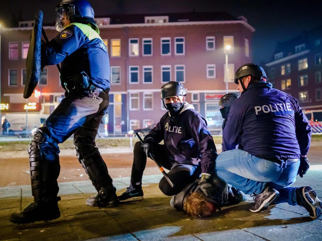 Dutch police arrest a man during clashes over Holland’s coronavirus curfews. Picture: AFP