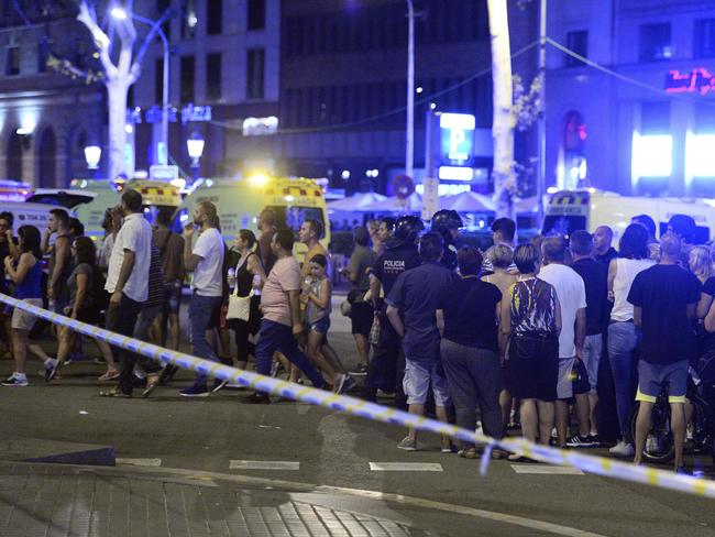 People gather to leave the cordoned off area after a van ploughed into the crowd on the Rambla in Barcelona. Picture: AFP