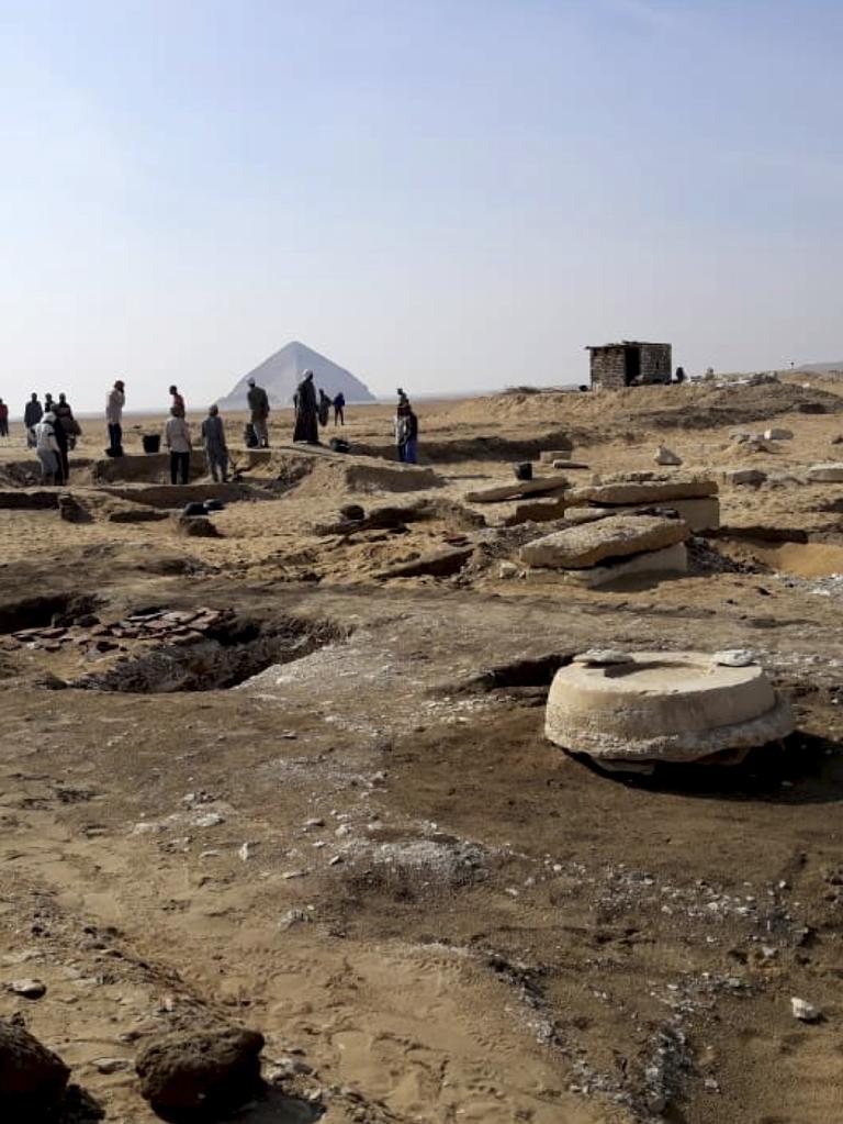 Archaeologists stand near an ancient mummy, found inside King Amenemhat II's pyramid. Picture: Egyptian Ministry of Antiquities