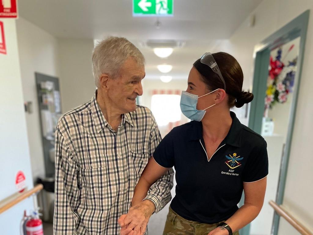 Australian Army medic Private Aliesha Hendy from 4th Health Battalion assists a resident of an aged-care facility in Brisbane as part of Operation COVID-19 Assist. .