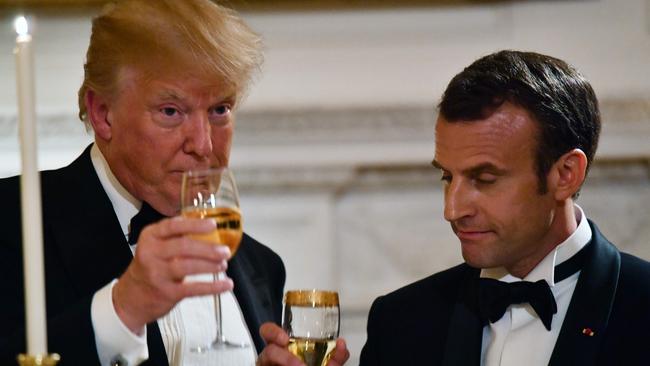 Donald Trump, left, shares a toast with French President Emmanuel Macron in 2018. The outgoing US president has said watching his older brother, Fred, struggle with alcoholism and die at the age of 40 caused him to avoid drinking. Picture: AFP