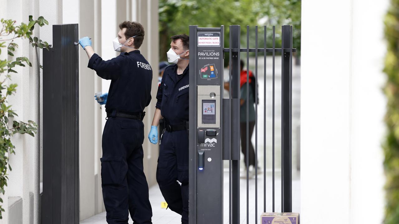 Forensic police dust for prints on a gate at the front the Homebush apartment block. Picture: NewsWire / Damian Shaw