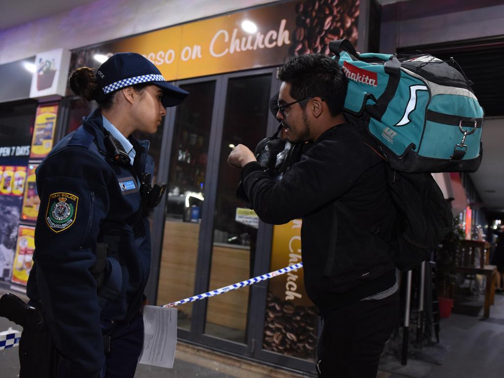 A resident talks to a police officer as authorities evacuate the complex. Picture: Flavio Brancaleone