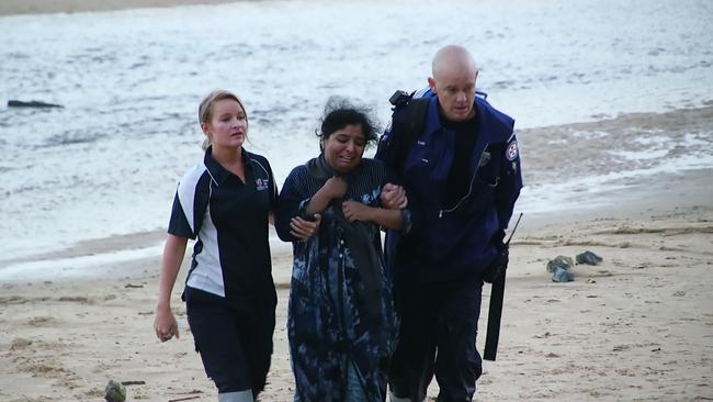 An upset woman is comforted by paramedics. Picture: Frank Redward