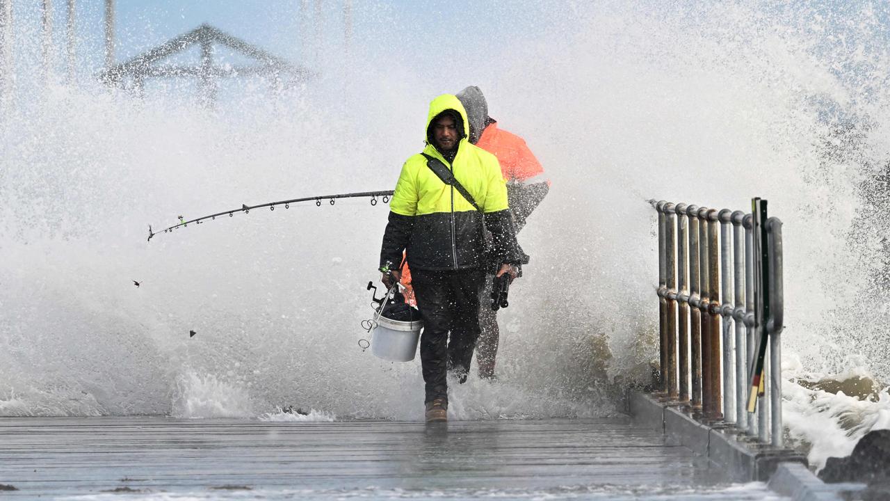 These anglers wisely beat a hasty retreat from a pier on Port Phillip Bay in Melbourne on September 2 as conditions worsened. Picture: William West/AFP