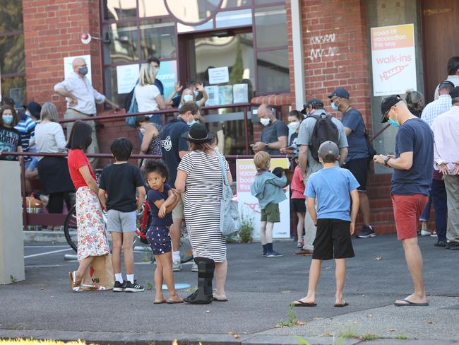 Parents and children line up at a West Melbourne vaccination clinic. Picture: David Caird