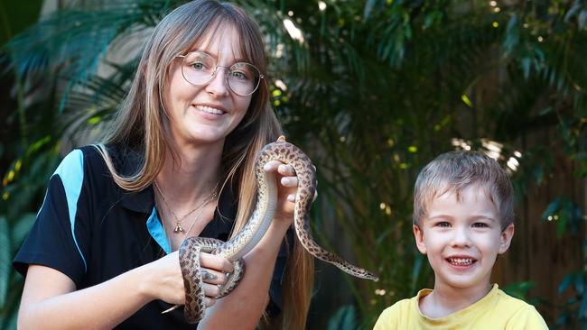 Cairns Central Childcare Centre director Shanice Robson shows Ramen the centre’s spotted python to kindergarten student Ezra Donaldson, 4, has very limited spaces for new children at the centre. Picture: Brendan Radke