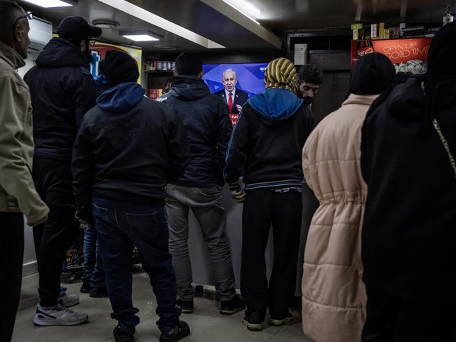 People watch Prime Minister Benjamin Netanyahu announce a ceasefire near Martyrs Square, where people sheltered as Israeli battered central Beirut. Picture: Getty Images