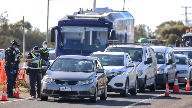 Victorian Police and Australian Defence Force personnel inspect cars at a vehicle checkpoint on the Princes Highway at Little River near Geelong. Picture: NCA NewsWire / Ian Currie