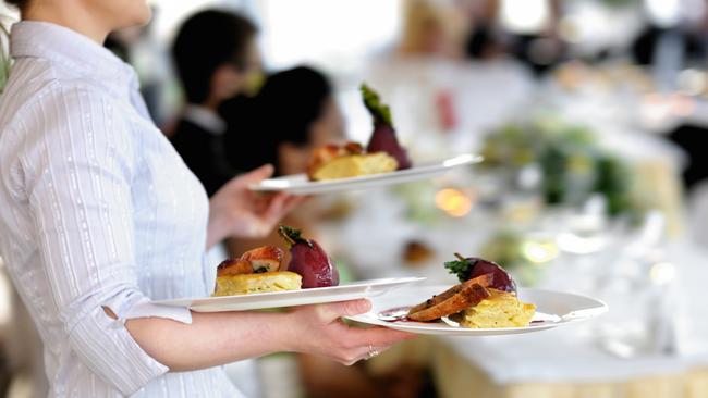 Waitress carrying three plates with meat dishGeneric photo of woman working in hospitality industry