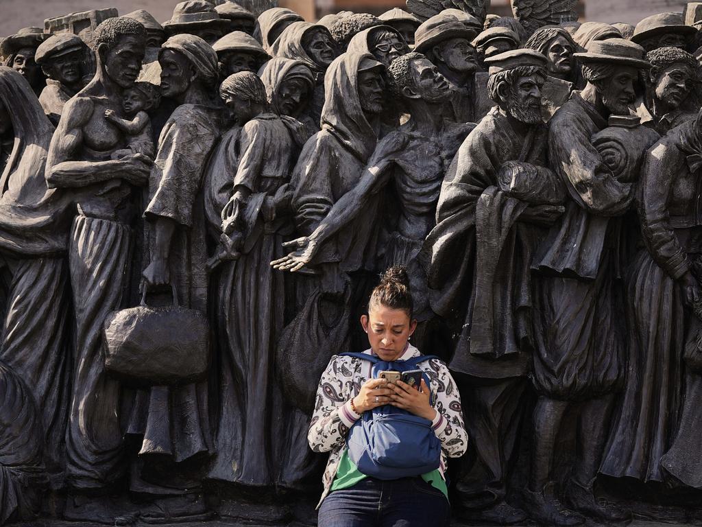 A woman sits on the Angels Unawares sculpture by Canadian artist Timothy P. Schmalz, which was inaugurated by the late Pope Francis and depicts migrants and refugees throughout history, in St. Peter's Square. Picture: AP