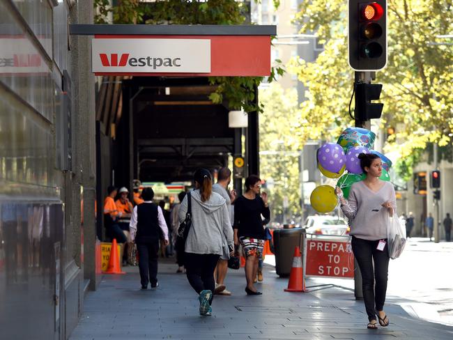 People walk past a Westpac Bank sign in Sydney on May 2, 2016, as the Australian banking heavyweight posted a three percent rise in interim net profit despite a volatile environment at a time of regulatory changes and bad debt fears. Westpac's 3.70 billion Australian dollars(2.81 billion USD) result in the six months to March 31 kicked off a week of half-yearly reporting from the nation's top lenders, which all face similar concerns. / AFP PHOTO / WILLIAM WEST
