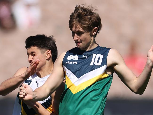 MELBOURNE, AUSTRALIA - SEPTEMBER 28: Thomas McGuane of Team Heppell kicks the ball under pressure from Felix Kneipp of Team Sloane during the Marsh AFL National Futures Boys match between Team Heppell and Team Sloane at Melbourne Cricket Ground, on September 28, 2024, in Melbourne, Australia. (Photo by Daniel Pockett/AFL Photos/via Getty Images)