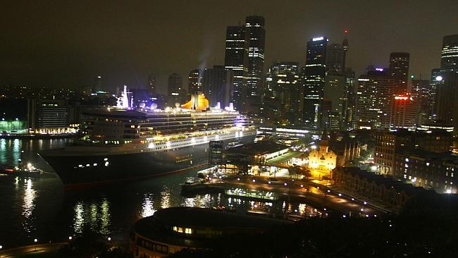 Queen Mary 2 eases in to dock at Circular Quay framed by the Sydney cityscape.
