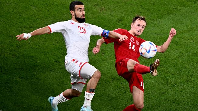 Tunisia's forward #23 Naim Sliti (L) fights for the ball with Denmark's midfielder #14 Mikkel Damsgaard (R).